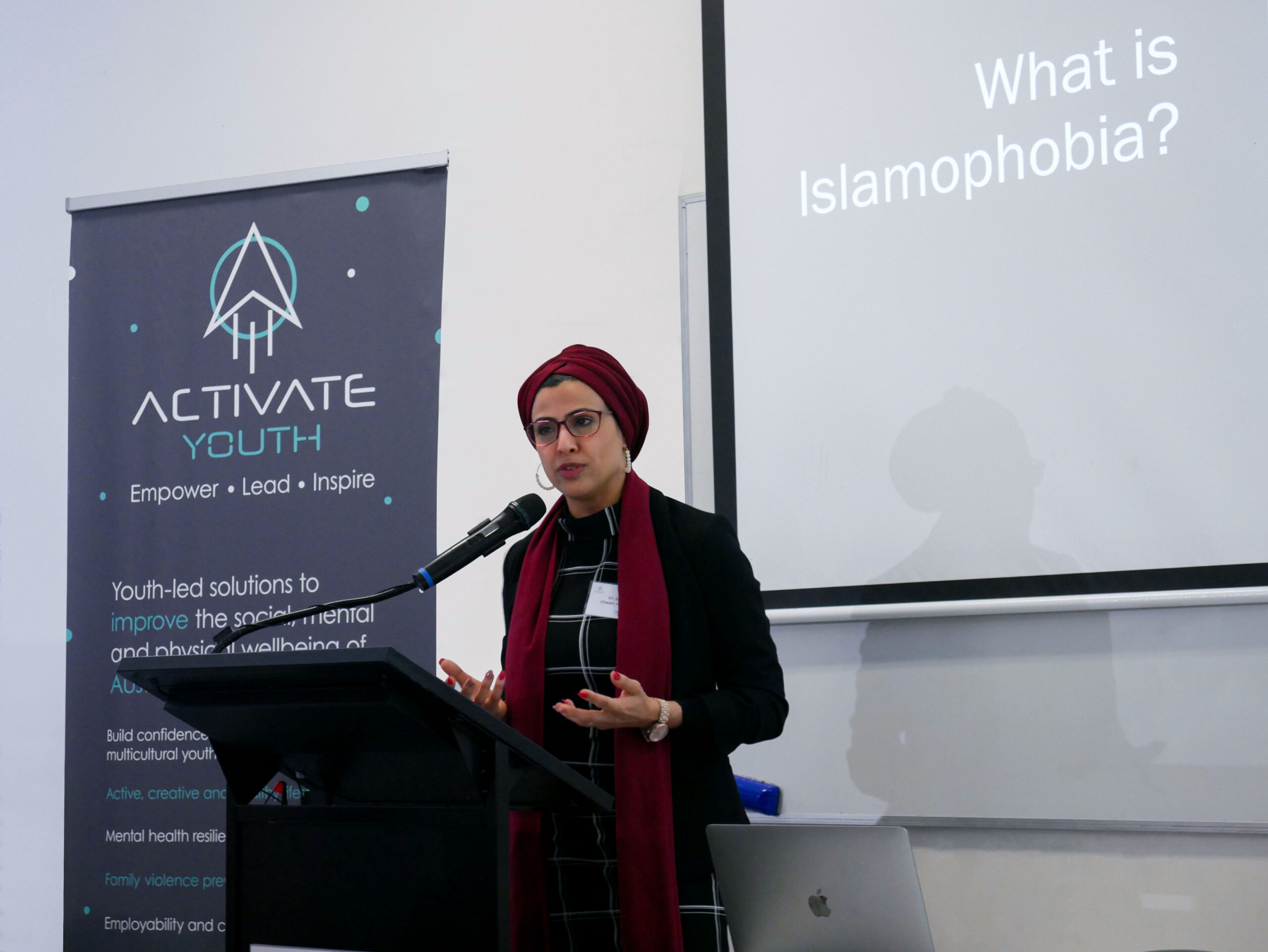 Dr. Sara Cheikh speaking at a podium